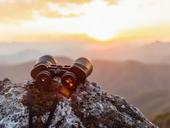 Binoculars looking into horizon, hopeful