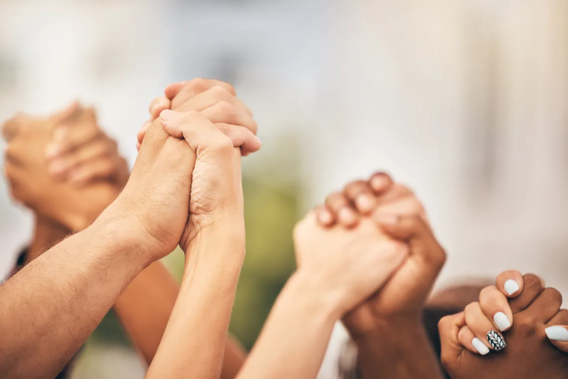 Several hands holding to each other in power fist, empowerment, together