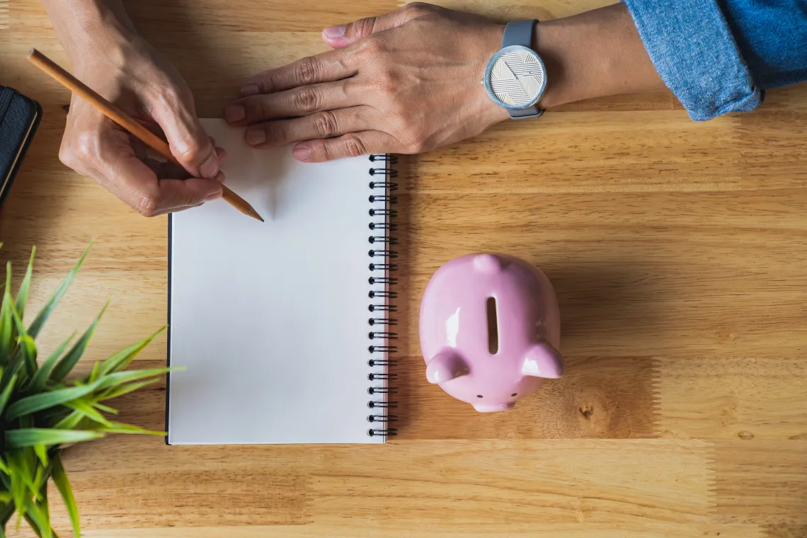 Notepad with piggy bank on side